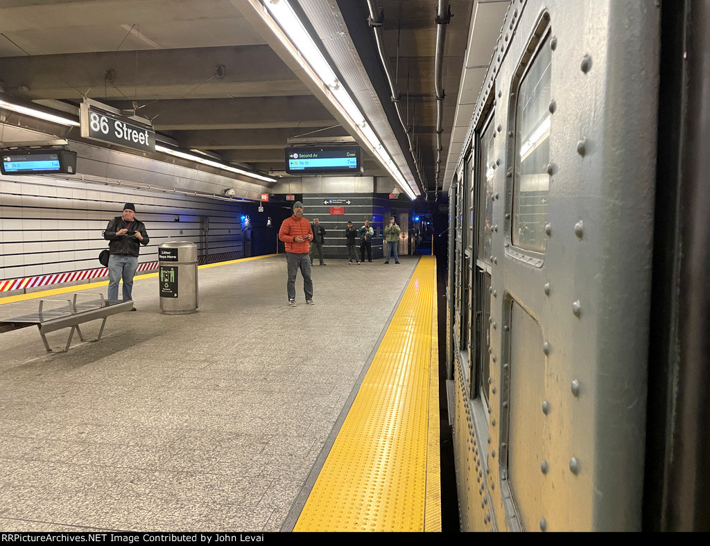 Transit fans get ready to record and photograph the Holiday Train, consisting of Arnines, depart 86th Street Station on the Q Line 